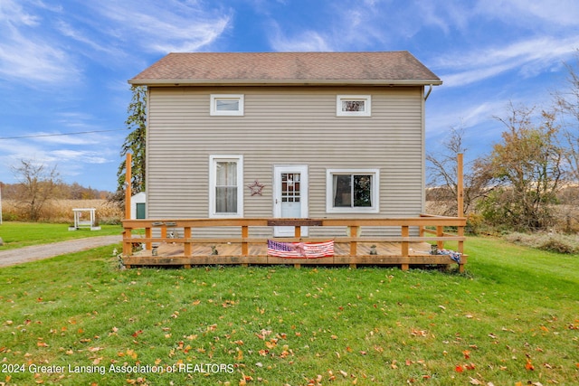 rear view of house featuring a lawn and a deck