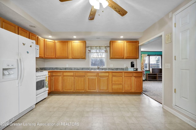 kitchen with white appliances, sink, ceiling fan, and light colored carpet