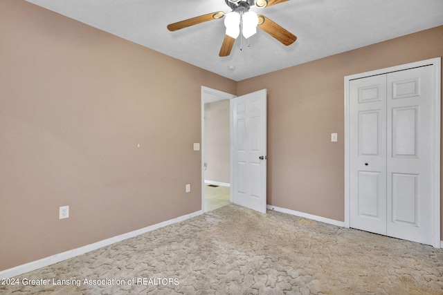 unfurnished bedroom featuring light carpet, ceiling fan, and a closet