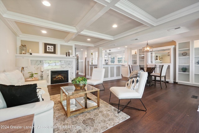 living room with a chandelier, beamed ceiling, dark wood-type flooring, coffered ceiling, and crown molding