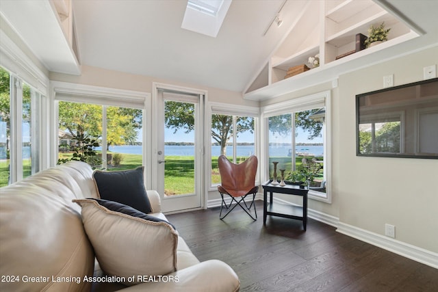 sunroom featuring vaulted ceiling with skylight, a water view, and rail lighting