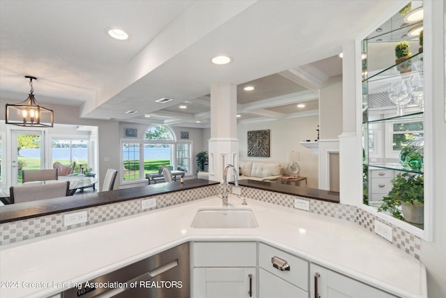 kitchen featuring sink, a notable chandelier, beam ceiling, white cabinetry, and coffered ceiling