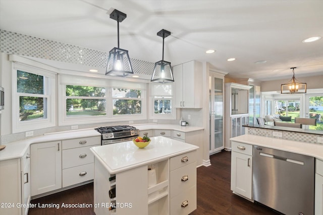 kitchen with hanging light fixtures, decorative backsplash, white cabinets, dark hardwood / wood-style flooring, and stainless steel appliances