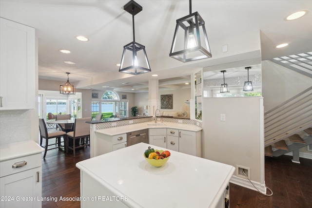 kitchen featuring pendant lighting, a kitchen island, white cabinetry, dishwasher, and dark hardwood / wood-style floors