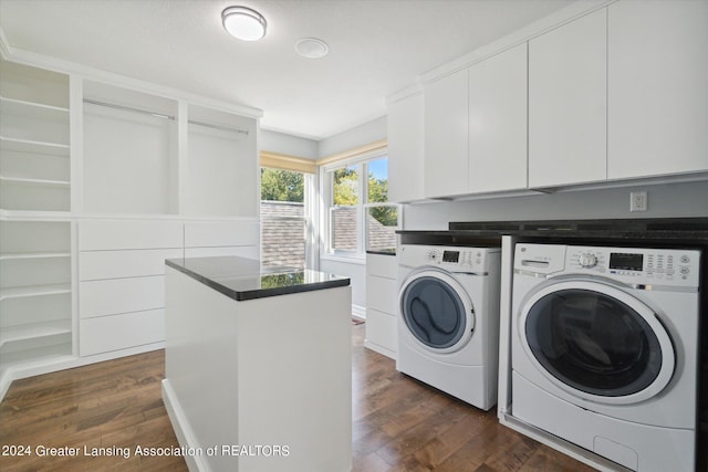 clothes washing area featuring washer and clothes dryer, dark hardwood / wood-style floors, and cabinets