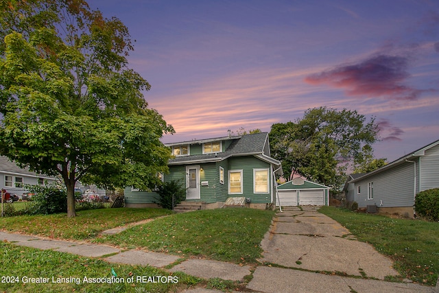 view of front of property featuring a lawn, an outbuilding, a garage, and cooling unit