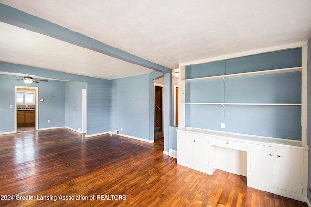 empty room with ceiling fan, hardwood / wood-style flooring, built in desk, and sink