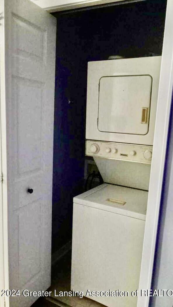 laundry area featuring stacked washer / drying machine