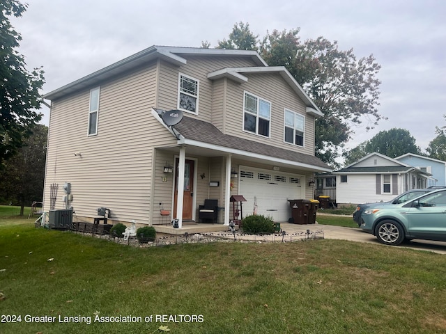 front facade featuring a front lawn, central AC unit, and a garage