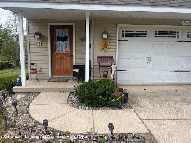 doorway to property with covered porch and a garage