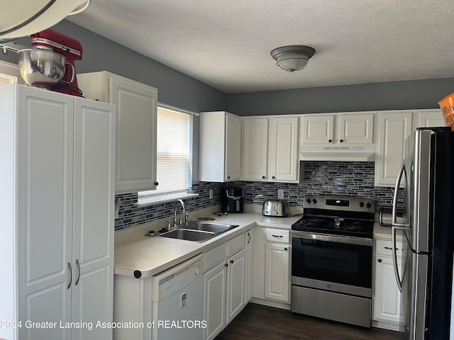 kitchen with sink, backsplash, dark hardwood / wood-style flooring, white cabinetry, and stainless steel appliances