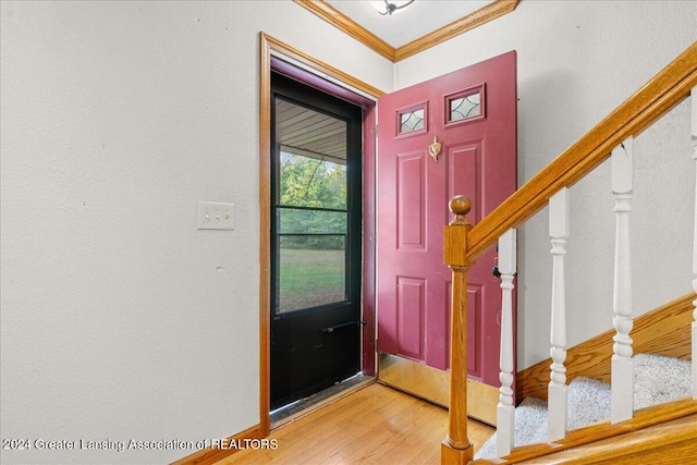 foyer entrance with ornamental molding and hardwood / wood-style flooring