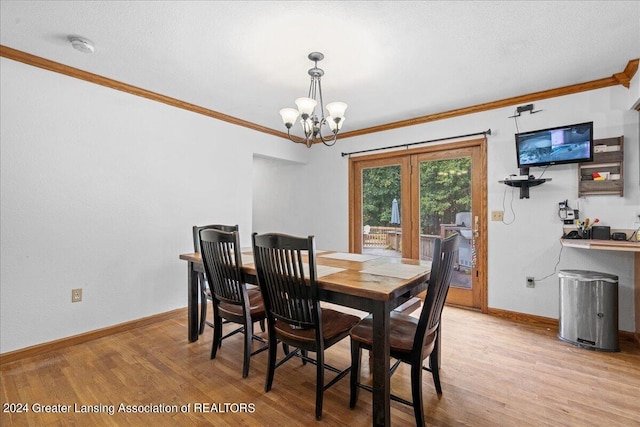 dining area featuring crown molding, light hardwood / wood-style flooring, and a notable chandelier