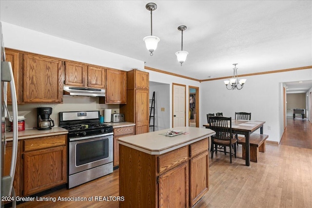 kitchen featuring light wood-type flooring, hanging light fixtures, a center island, and stainless steel range with gas stovetop