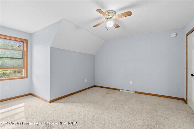 additional living space with light carpet, lofted ceiling, ceiling fan, and a baseboard radiator