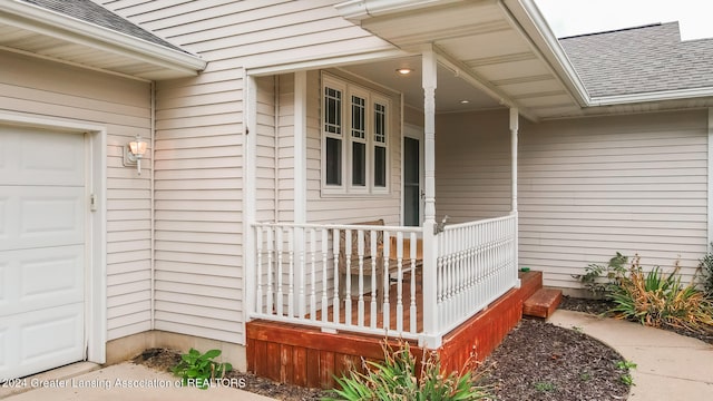 doorway to property with a porch and a garage