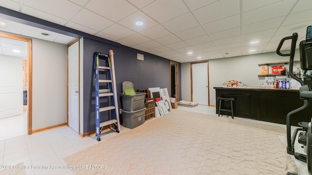 interior space with a paneled ceiling and tile patterned flooring