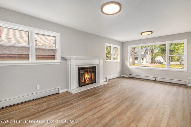 unfurnished living room with a baseboard radiator and light wood-type flooring