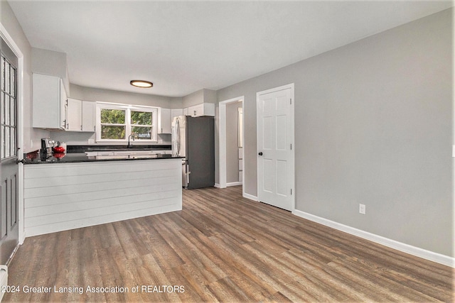 kitchen featuring dark hardwood / wood-style flooring, white cabinets, and stainless steel fridge