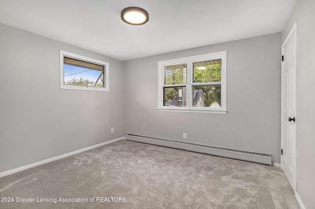 carpeted spare room featuring a baseboard radiator