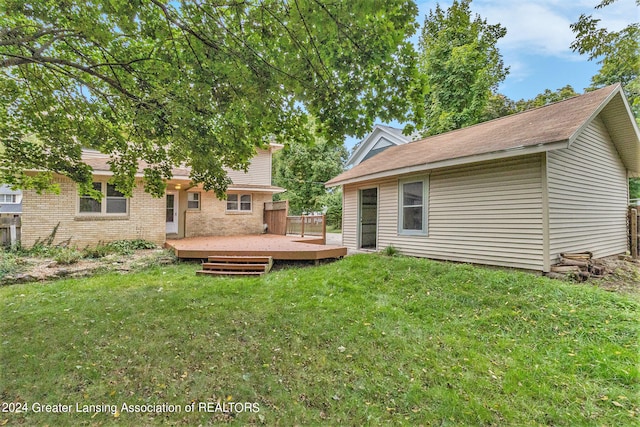 rear view of house with a yard and a wooden deck