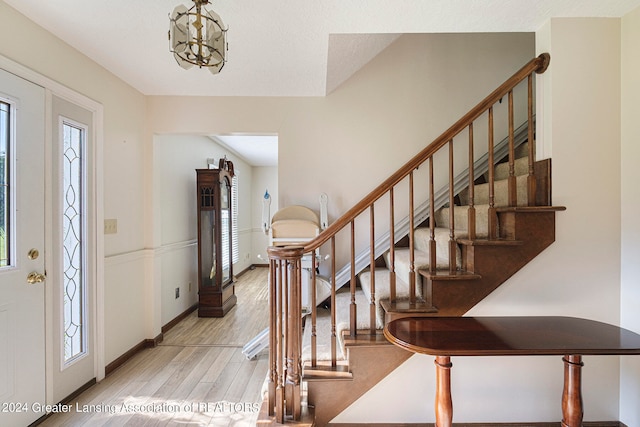 foyer entrance featuring light hardwood / wood-style floors, a chandelier, and a wealth of natural light