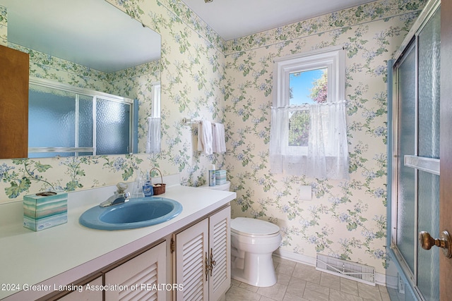 full bathroom with tile patterned flooring, enclosed tub / shower combo, vanity, and toilet