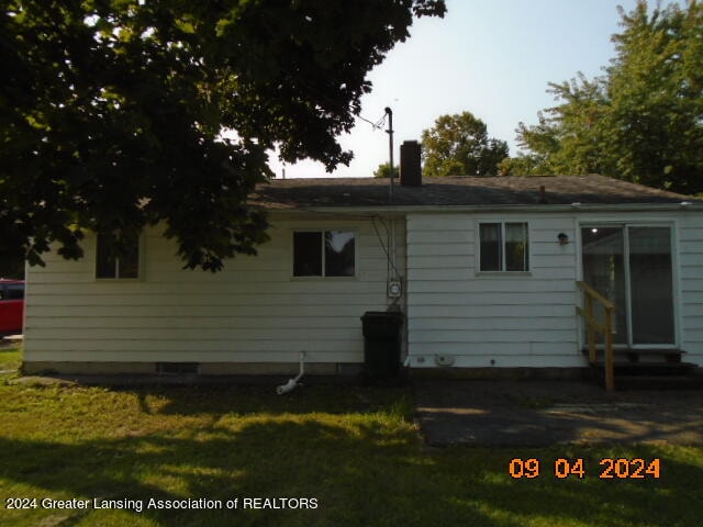 rear view of property with a yard