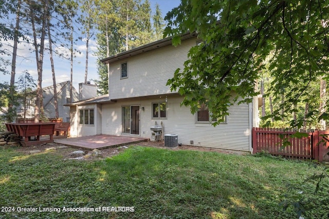 back of house featuring central AC unit, a yard, and a wooden deck