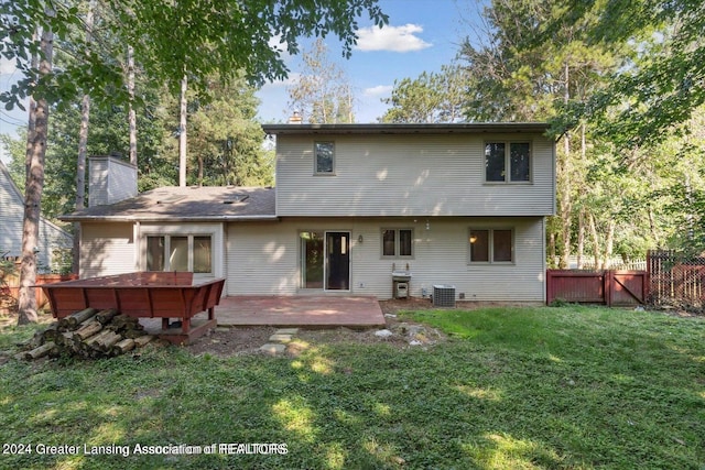 back of property featuring central AC, a deck, and a yard