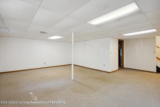 basement with light carpet and a paneled ceiling