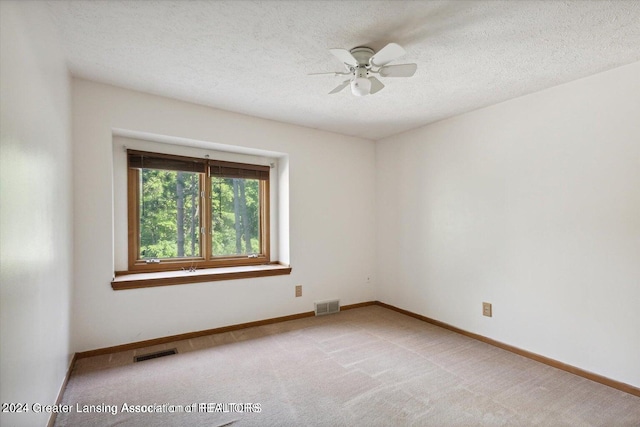 carpeted empty room featuring ceiling fan and a textured ceiling