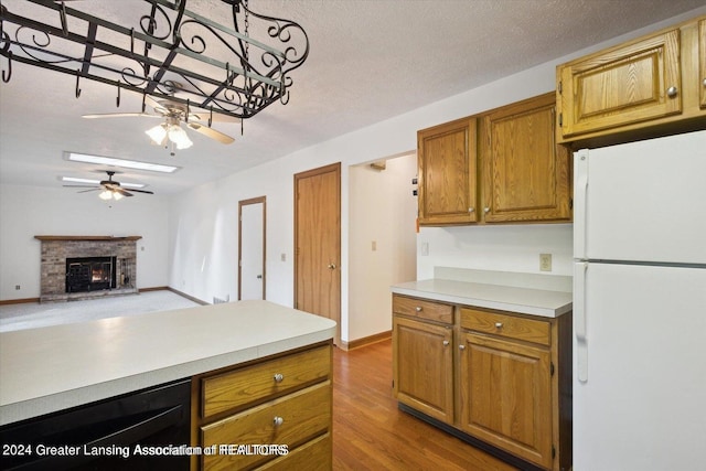 kitchen featuring a brick fireplace, white refrigerator, beverage cooler, ceiling fan, and hardwood / wood-style floors