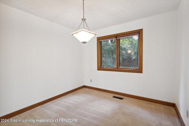 carpeted empty room featuring a textured ceiling