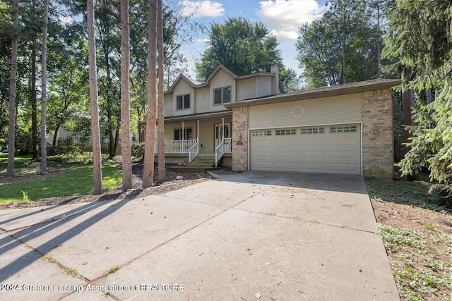 front facade featuring a garage, a front yard, and covered porch