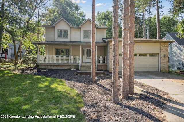 view of front of home featuring a front yard, a garage, and covered porch