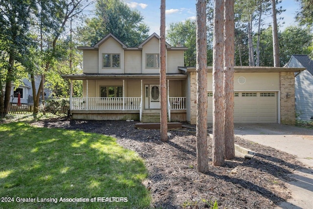 front of property featuring a garage, a front yard, and covered porch