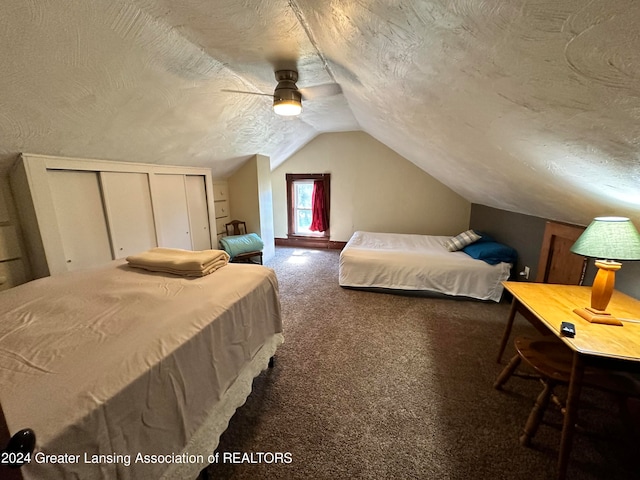 bedroom with a closet, a textured ceiling, lofted ceiling, carpet floors, and ceiling fan