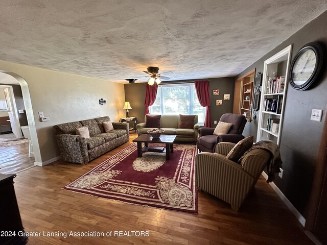 living room featuring a textured ceiling, hardwood / wood-style floors, and ceiling fan