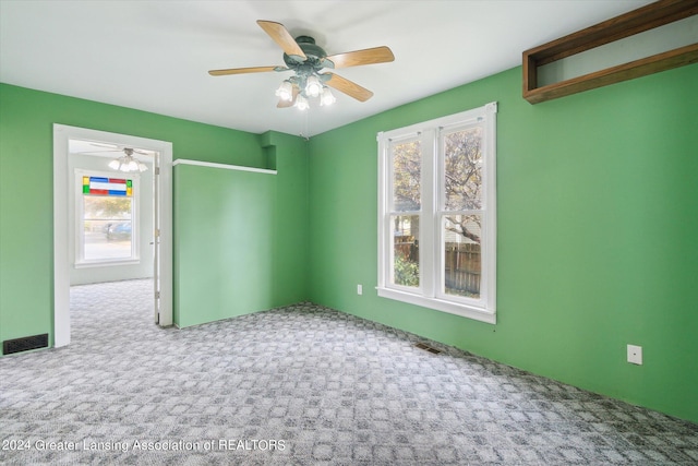 spare room with carpet, ceiling fan, and plenty of natural light