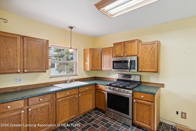 kitchen featuring sink, hanging light fixtures, and stainless steel appliances