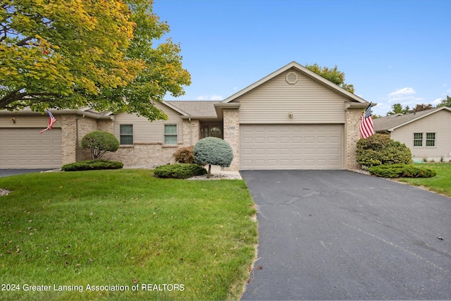 single story home featuring a garage and a front lawn