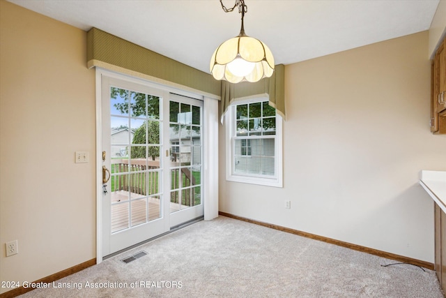 unfurnished dining area with light carpet