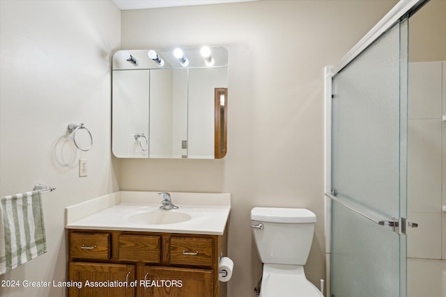 bathroom featuring vanity, toilet, and an enclosed shower