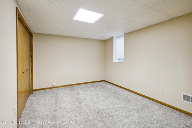 carpeted spare room featuring a paneled ceiling