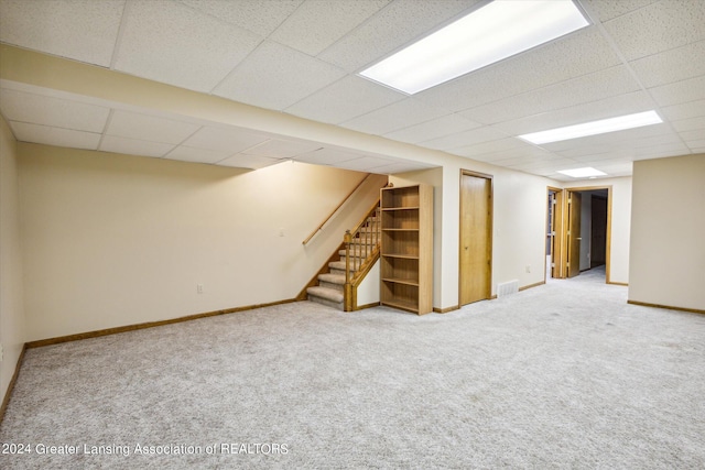 basement with a drop ceiling and carpet flooring