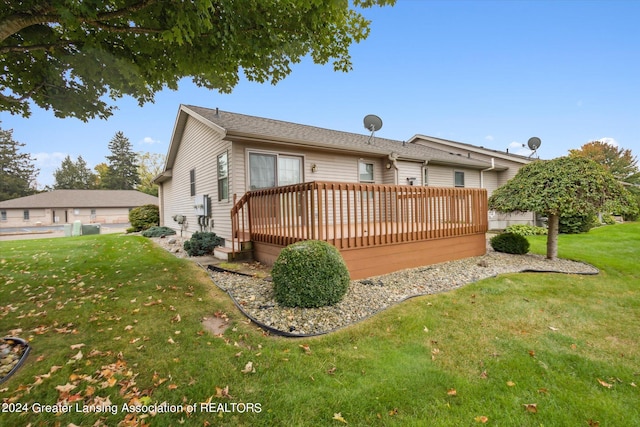 back of property with a yard and a wooden deck