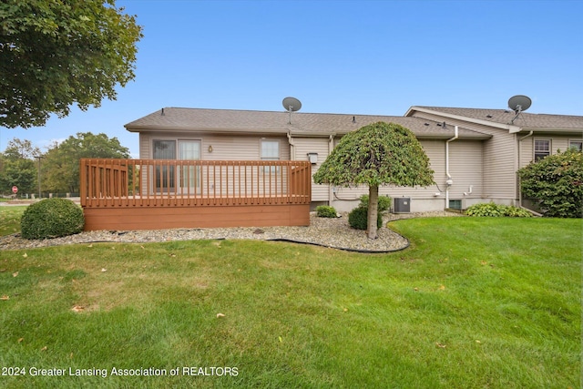 back of property featuring a wooden deck, cooling unit, and a lawn