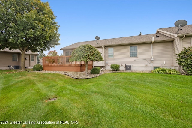 rear view of property with a yard and a wooden deck