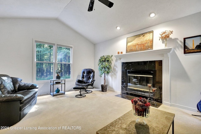 carpeted living room with a tile fireplace, vaulted ceiling, and ceiling fan